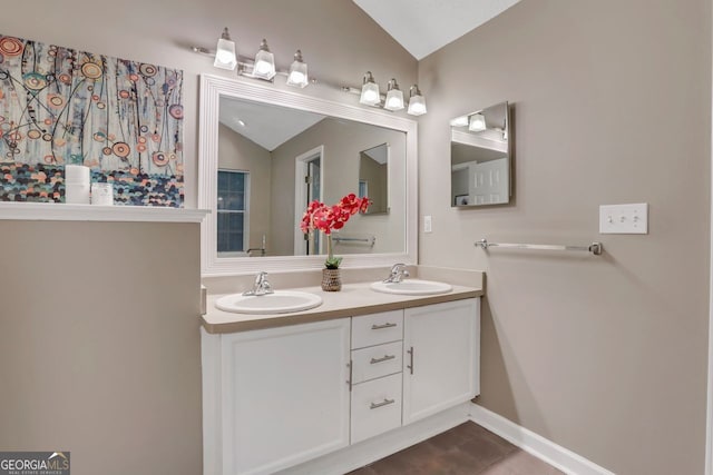 bathroom featuring vanity, tile patterned flooring, and vaulted ceiling