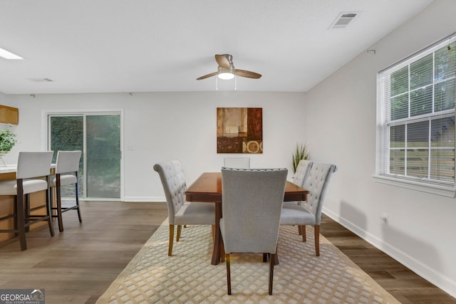 dining space featuring ceiling fan and dark hardwood / wood-style flooring