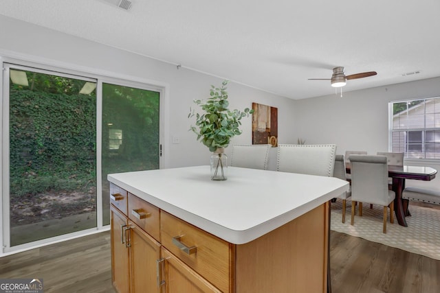 kitchen featuring ceiling fan, dark hardwood / wood-style flooring, and a center island