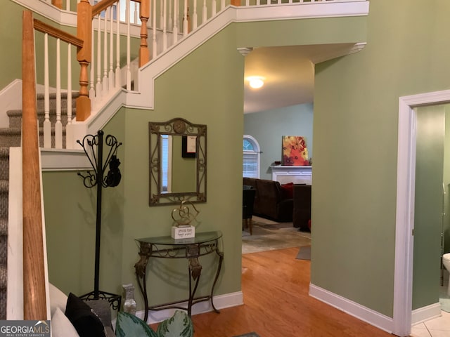 stairs with a high ceiling, wood-type flooring, and plenty of natural light