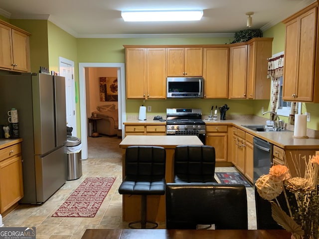 kitchen featuring ornamental molding, stainless steel appliances, light brown cabinetry, sink, and a breakfast bar area