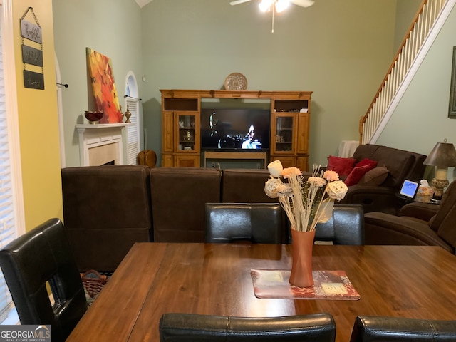 carpeted living room with a towering ceiling, a healthy amount of sunlight, and a fireplace