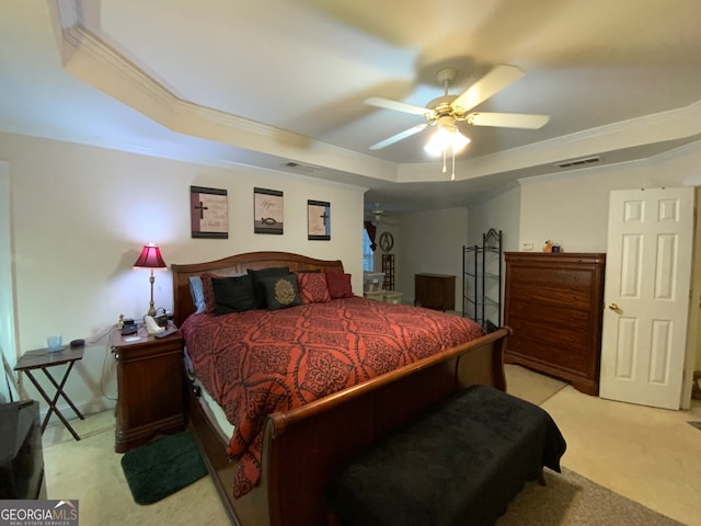 bedroom with light colored carpet, ceiling fan, crown molding, and a tray ceiling