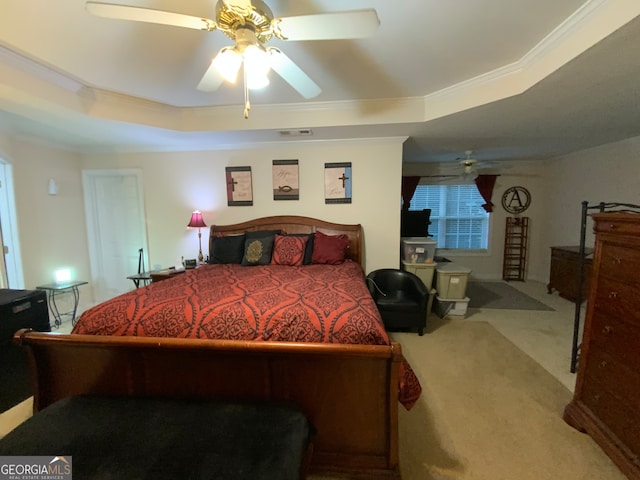 carpeted bedroom featuring ceiling fan, a raised ceiling, and ornamental molding