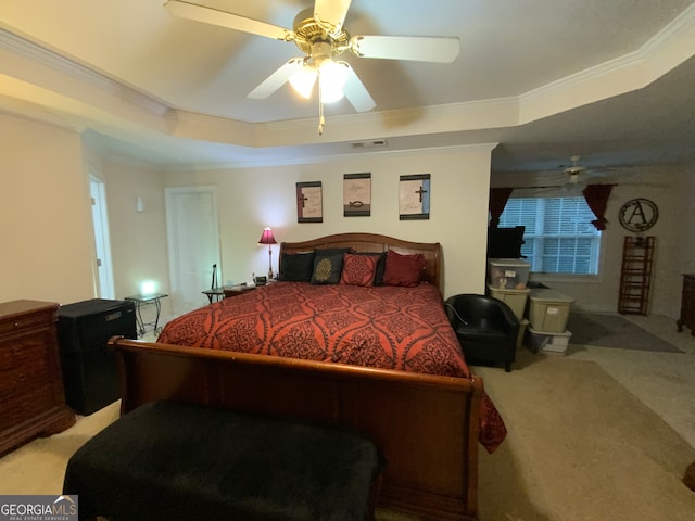 carpeted bedroom featuring crown molding, ceiling fan, and a raised ceiling