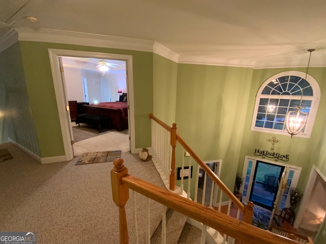 hallway with ornamental molding and light carpet