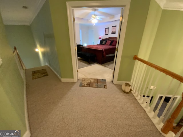 stairs with a chandelier, carpet floors, and ornamental molding