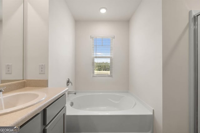 bathroom featuring vanity and a tub