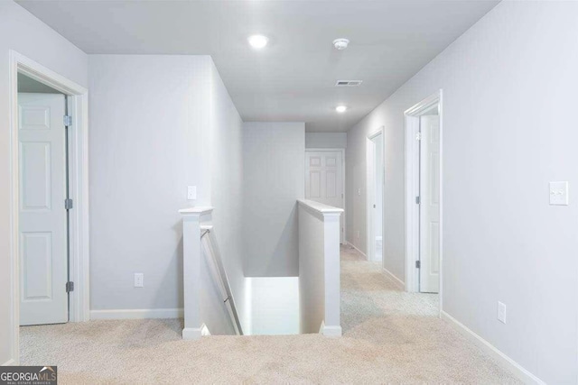 hallway with light colored carpet