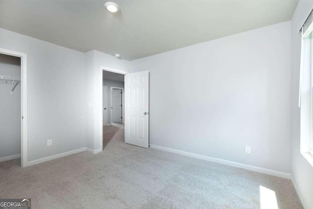 unfurnished bedroom featuring a closet and light colored carpet