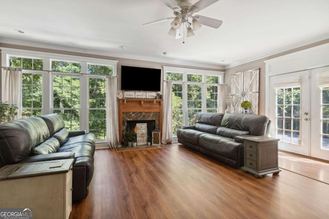 living room featuring a premium fireplace, ornamental molding, french doors, and wood finished floors