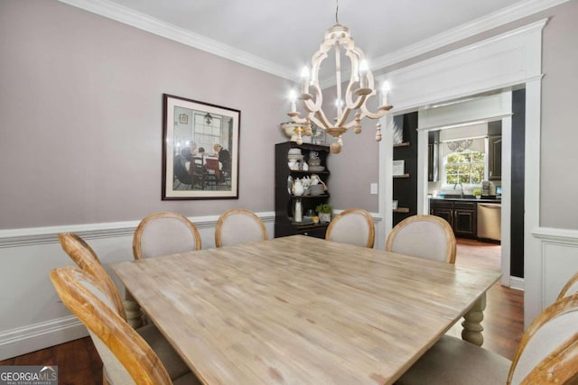 dining space featuring baseboards, crown molding, an inviting chandelier, and wood finished floors