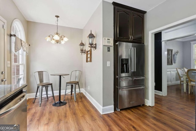 kitchen featuring dark wood-style floors, baseboards, dark brown cabinetry, appliances with stainless steel finishes, and a chandelier