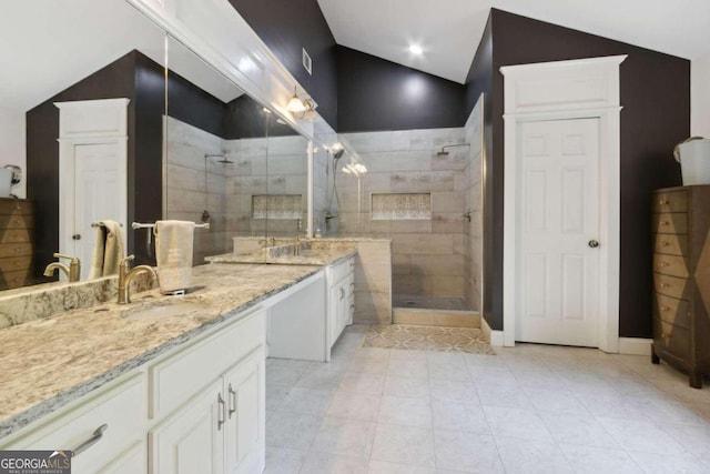 bathroom with vanity, lofted ceiling, and a walk in shower