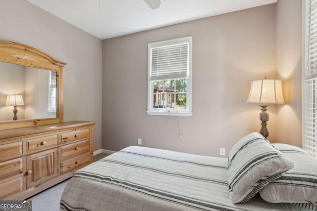 carpeted bedroom featuring baseboards and ceiling fan