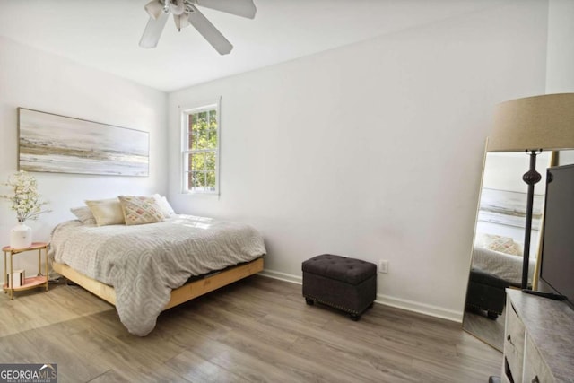 bedroom featuring a ceiling fan, baseboards, and wood finished floors