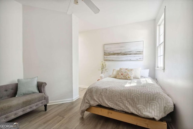 bedroom featuring ceiling fan, baseboards, and wood finished floors