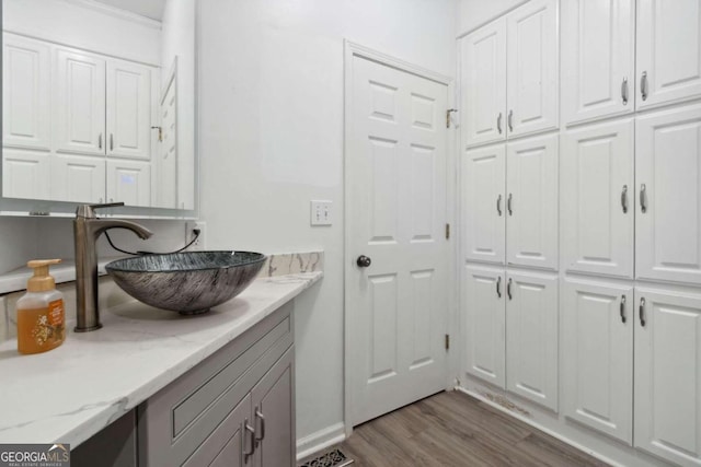 laundry area with dark wood-style flooring and a sink