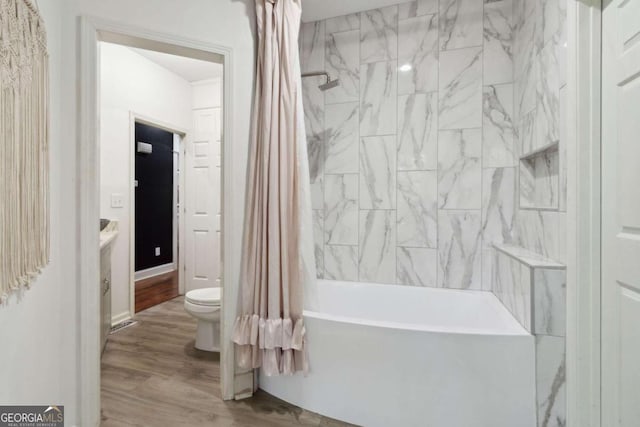 bathroom with toilet, shower / tub combo, baseboards, and wood finished floors