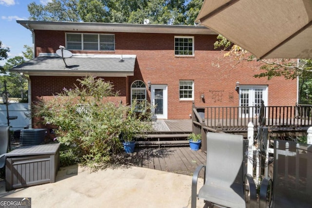 rear view of property with french doors, central air condition unit, brick siding, and a deck