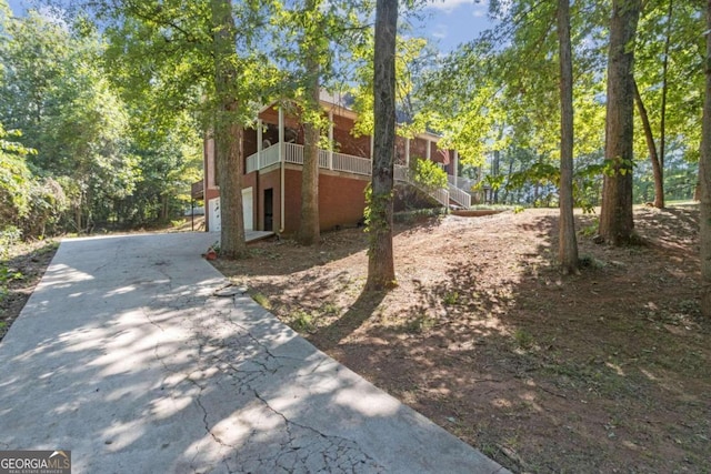 view of home's exterior with stairway, concrete driveway, and a garage