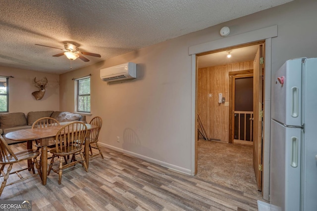 dining space featuring a textured ceiling, ceiling fan, wooden walls, and a wall mounted air conditioner