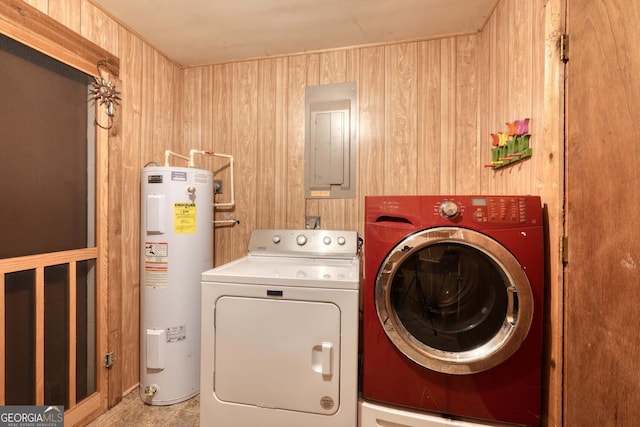 washroom with electric panel, washer and dryer, water heater, wood walls, and laundry area