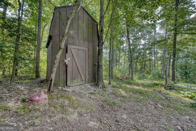 view of outdoor structure featuring a view of trees and an outdoor structure