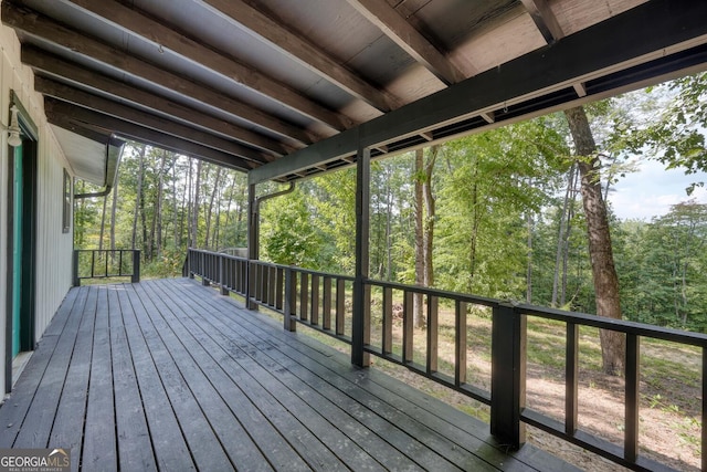 wooden terrace featuring a view of trees