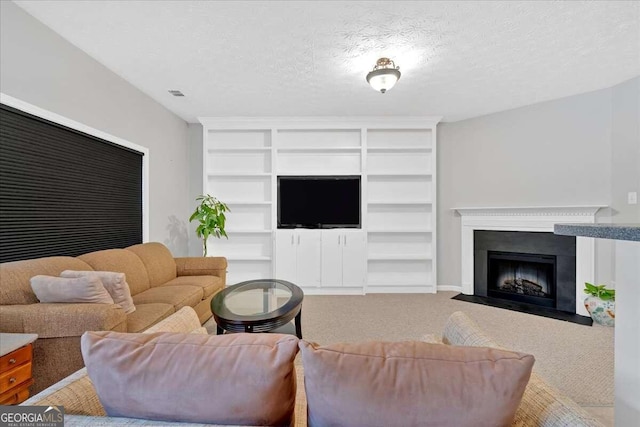 carpeted living area with a textured ceiling, built in shelves, a fireplace with flush hearth, and visible vents