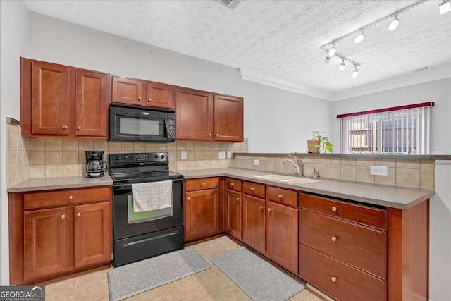 kitchen with a peninsula, black appliances, decorative backsplash, and a sink