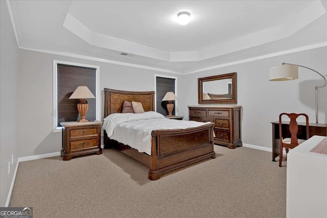 carpeted bedroom with a tray ceiling, visible vents, and baseboards