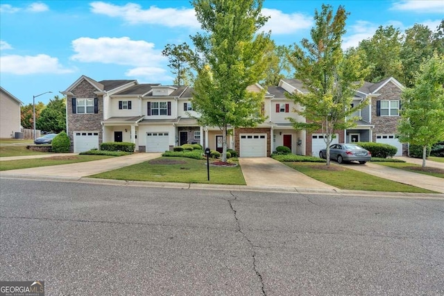 multi unit property featuring a garage, driveway, and a front lawn