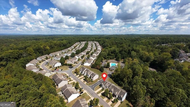 drone / aerial view featuring a residential view and a wooded view