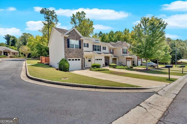 townhome / multi-family property with a garage and a front lawn