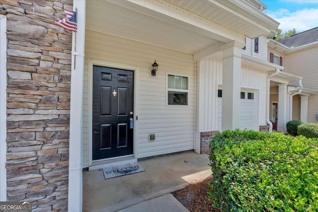 property entrance with a garage and a porch