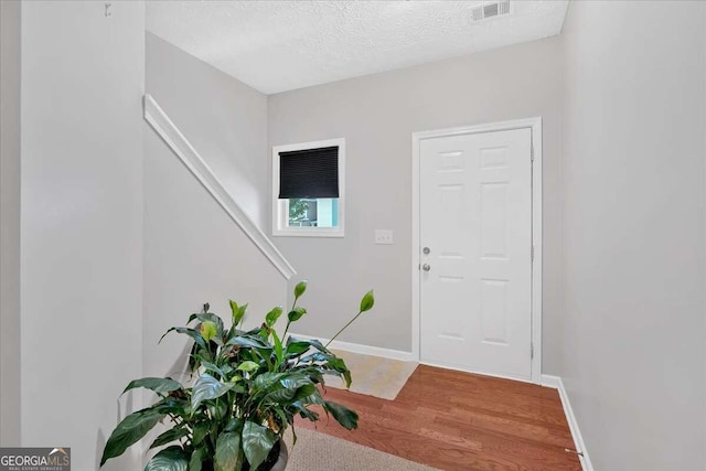 foyer entrance featuring a textured ceiling and hardwood / wood-style flooring