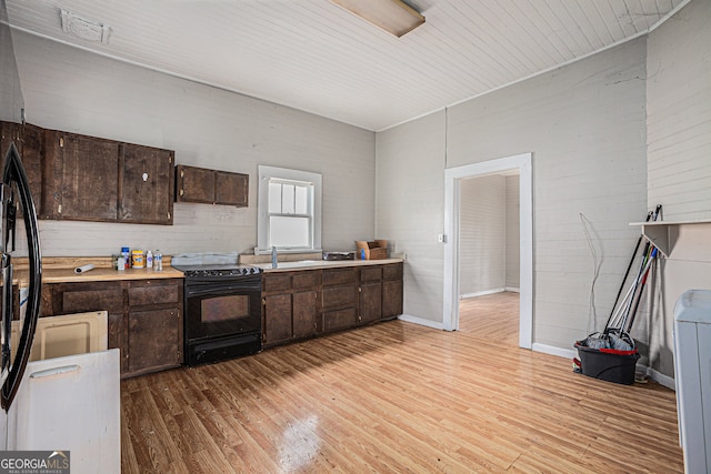 kitchen featuring wood ceiling, electric range, light hardwood / wood-style floors, sink, and dark brown cabinetry