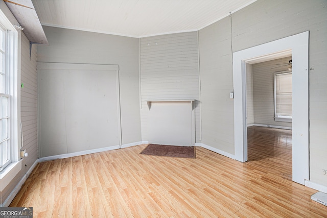 empty room with crown molding and light hardwood / wood-style floors