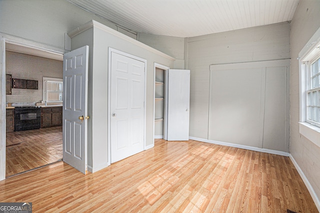 unfurnished bedroom featuring lofted ceiling and hardwood / wood-style flooring