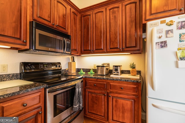 kitchen with stainless steel appliances and dark stone counters