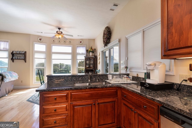 kitchen with ceiling fan, dishwasher, dark stone countertops, and light hardwood / wood-style floors