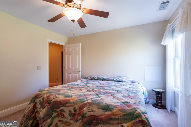 bedroom with ceiling fan, light carpet, and multiple windows