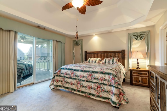 bedroom featuring a tray ceiling, ceiling fan, access to exterior, and light colored carpet