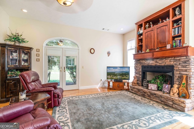 199 Colonsay Trce, Blairsville, GA 30512 - living room with visible vents, baseboards, a stone fireplace, light wood-style flooring, and french doors