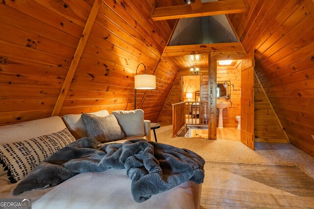 interior space featuring lofted ceiling with beams, wooden walls, and wood ceiling