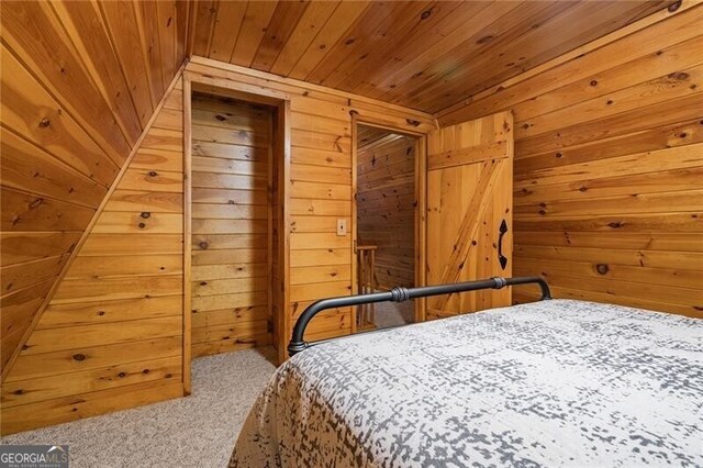 bedroom with wood walls, carpet flooring, and wooden ceiling