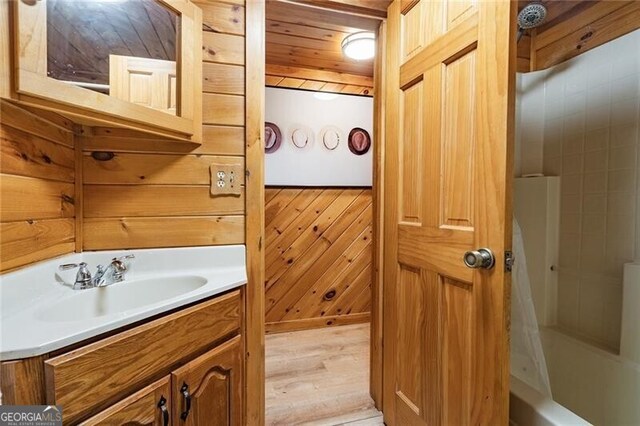 bathroom with vanity, wood-type flooring, and wood walls