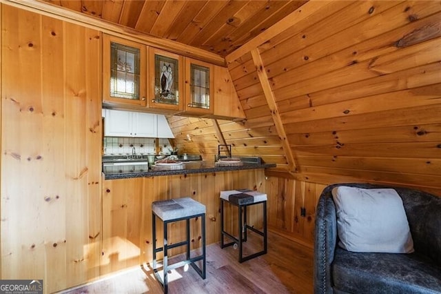 sitting room featuring hardwood / wood-style floors, wood ceiling, and wooden walls