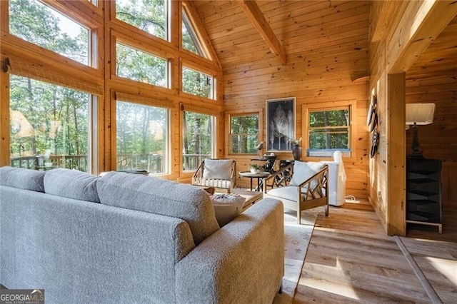 sunroom / solarium featuring lofted ceiling with beams, wood ceiling, and a healthy amount of sunlight